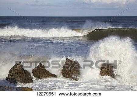 Stock Image - Waves crashing on the rocks by the shore; South Shields, Tyne and Wear, England. Fotosearch