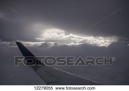 Wing of an airplane with sunlight shining through storm clouds; Astoria, Oregon, United States of America View Large Photo Image Stock Photography - Wing of an airplane with sunlight shining through storm clouds; Astoria, Oregon, United States of America. Fotosearch