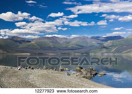 Woman photographs stacked rocks along Kluane Lake, Yukon Territory, Canada View Large Photo Image Stock Image - Woman photographs stacked rocks along Kluane Lake, Yukon Territory, Canada. Fotosearch