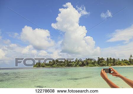 Woman taking a picture of an atoll with a smart phone; Medahutthaa Island, North Huvadhoo Atoll, Southern Maldives View Large Photo Image Stock Photo - Woman taking a picture of an atoll with a smart phone; Medahutthaa Island, North Huvadhoo Atoll, Southern Maldives. Fotosearch