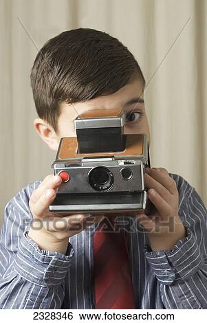 Stock Photograph - Young Boy With Old Polaroid Instant Camera; Laval, Quebec, Canada. Fotosearch