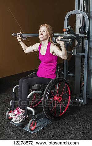 Young disabled woman using a shoulder press to rehabilitate herself from a spinal injury; Edmonton, Alberta, Canada View Large Photo Image Stock Image - Young disabled woman using a shoulder press to rehabilitate herself from a spinal injury; Edmonton, Alberta, Canada. Fotosearch