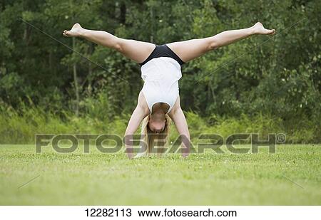 Young female gymnast practicing her handstand splits outdoors in a park; Edmonton, Alberta, Canada View Large Photo Image Stock Image - Young female gymnast practicing her handstand splits outdoors in a park; Edmonton, Alberta, Canada. Fotosearch