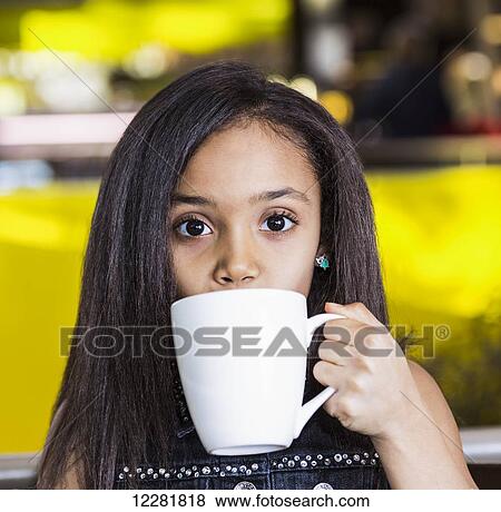 Young girl drinking hot chocolate in a cafeteria at a shopping mall; St. Albert, Alberta, Canada View Large Photo Image Stock Photo - Young girl drinking hot chocolate in a cafeteria at a shopping mall; St. Albert, Alberta, Canada. Fotosearch