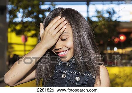 Young girl holding her hand on her head because she forgot something when out shopping; St. Albert, Alberta, Canada View Large Photo Image Stock Photography - Young girl holding her hand on her head because she forgot something when out shopping; St. Albert, Alberta, Canada. Fotosearch
