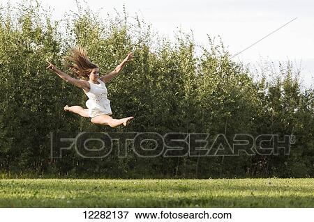 Young gymnast teenager practicing her split jump in a park in a dress; Edmonton, Alberta, Canada View Large Photo Image Stock Photo - Young gymnast teenager practicing her split jump in a park in a dress; Edmonton, Alberta, Canada. Fotosearch