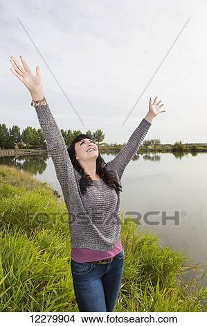 Young woman raising her hands in worship at a city park in autumn; St. Albert, Alberta, Canada View Large Photo Image Picture - Young woman raising her hands in worship at a city park in autumn; St. Albert, Alberta, Canada. Fotosearch