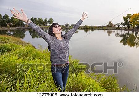 Young woman raising her hands in worship at a city park in autumn; St. Albert, Alberta, Canada View Large Photo Image Stock Photograph - Young woman raising her hands in worship at a city park in autumn; St. Albert, Alberta, Canada. Fotosearch