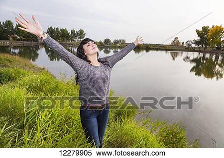 Young woman raising her hands in worship at a city park in autumn; St. Albert, Alberta, Canada View Large Photo Image Stock Photography - Young woman raising her hands in worship at a city park in autumn; St. Albert, Alberta, Canada. Fotosearch