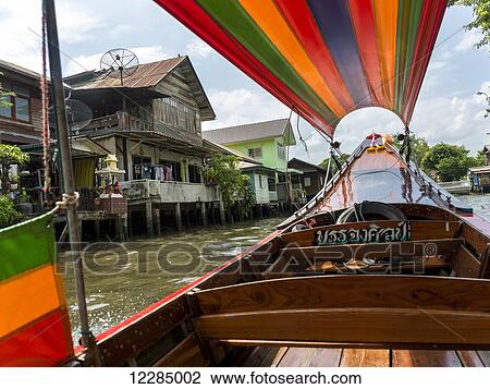 A boat on the river with a colourful cover and houses along the shoreline; Bangkok, Thailand View Large Photo Image Stock Image - A boat on the river with a colourful cover and houses along the shoreline; Bangkok, Thailand. Fotosearch