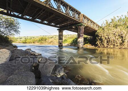 Stock Photograph - A bridge crossing over the Jordan River; Israel. Fotosearch