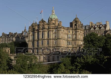 Stock Photograph - A building with a Union Jack flag and green dome against a blue sky; Edinburgh, Scotland. Fotosearch