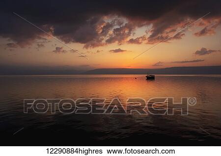 Stock Photograph - A calm settles on the Sea of Galilee, just after a storm; Galilee, Israel. Fotosearch