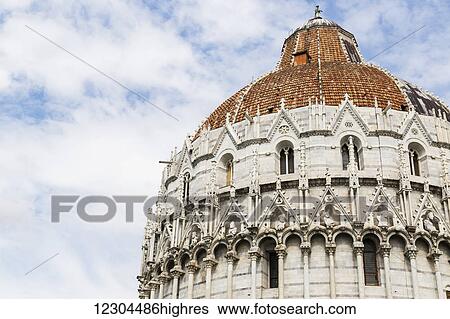 Stock Photograph - A close cropped viewpoint of the architecture of the dome at Piazza dei Miracoli, the baptistry and the dome; Pisa, Tuscany, Italy. Fotosearch