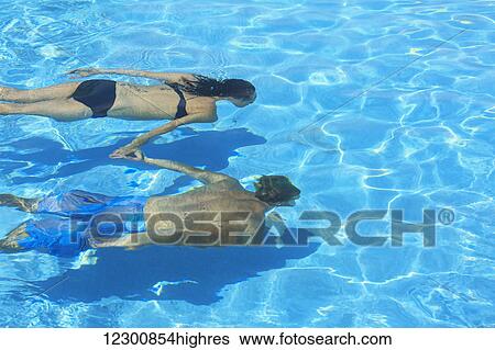 A couple swimming underwater in a pool, Saint Georges Caye Resort; Belize City, Belize View Large Photo Image Stock Photograph - A couple swimming underwater in a pool, Saint Georges Caye Resort; Belize City, Belize. Fotosearch