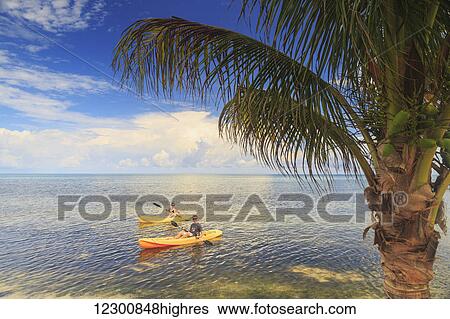 A couple using kayaks at Saint Georges Caye Resort; Belize City, Belize View Large Photo Image Stock Photograph - A couple using kayaks at Saint Georges Caye Resort; Belize City, Belize. Fotosearch