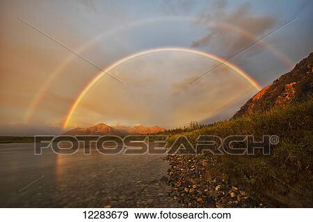 A double rainbow forms at sunset over the mountains along the Wind River in the Peel Watershed; Yukon, Canada View Large Photo Image Stock Photo - A double rainbow forms at sunset over the mountains along the Wind River in the Peel Watershed; Yukon, Canada. Fotosearch