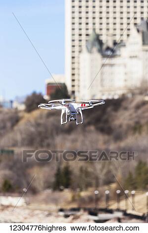 Stock Photograph - A drone flying in the river valley with buildings in the distance; Edmonton, Alberta, Canada. Fotosearch