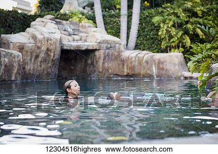 A family enjoys an afternoon in the pool on a sunny afternoon; Fountain Valley, California, United States of America View Large Photo Image Stock Photograph - A family enjoys an afternoon in the pool on a sunny afternoon; Fountain Valley, California, United States of America. Fotosearch