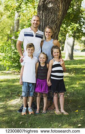 A family posing for a family portrait in a park; Edmonton, Alberta, Canada View Large Photo Image Stock Photograph - A family posing for a family portrait in a park; Edmonton, Alberta, Canada. Fotosearch
