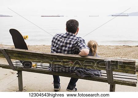 A father and his little girl sit on a bench and watch the ships anchored in the sea; Vancouver, British Columbia, Canada View Large Photo Image Stock Photograph - A father and his little girl sit on a bench and watch the ships anchored in the sea; Vancouver, British Columbia, Canada. Fotosearch
