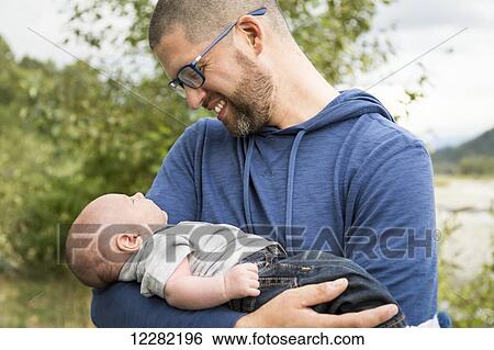 A father holding his infant son; Chilliwack, British Columbia, Canada View Large Photo Image Stock Photograph - A father holding his infant son; Chilliwack, British Columbia, Canada. Fotosearch