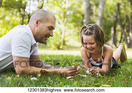 Stock Photograph - A father spending quality time with his daughter in a park during a family outing; Edmonton, Alberta, Canada. Fotosearch