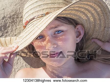 A girl laying on the sand wearing a sunhat; Tarifa, Cadiz, Andalusia, Spain View Large Photo Image Stock Photograph - A girl laying on the sand wearing a sunhat; Tarifa, Cadiz, Andalusia, Spain. Fotosearch