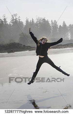 A girl leaping in mid-air on a wet beach; Tofino, British Columbia, Canada View Large Photo Image Stock Photograph - A girl leaping in mid-air on a wet beach; Tofino, British Columbia, Canada. Fotosearch