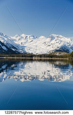 A glacier hangs in a valley below jagged snow covered peaks in Kings Bay, Prince William Sound; Whittier, Alaska, United States of America View Large Photo Image Stock Photograph - A glacier hangs in a valley below jagged snow covered peaks in Kings Bay, Prince William Sound; Whittier, Alaska, United States of America. Fotosearch