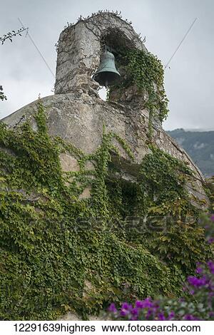 Stock Photograph - A green bell in a niche over a wall covered in vines; Laurito, Campania, Italy. Fotosearch