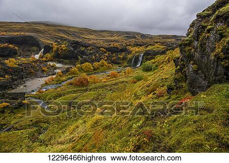 Stock Photograph - A group of waterfalls collectively known as Gjain; Iceland. Fotosearch