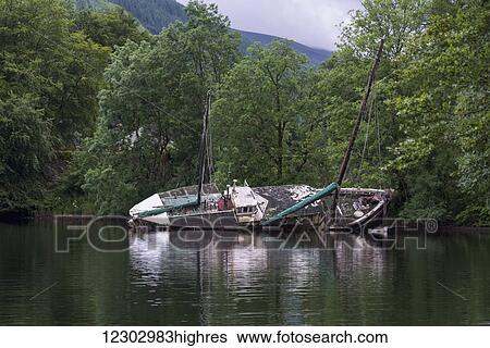 A large boat with masts tipped over in Loch Oich; Scotland View Large Photo Image Stock Photograph - A large boat with masts tipped over in Loch Oich; Scotland. Fotosearch