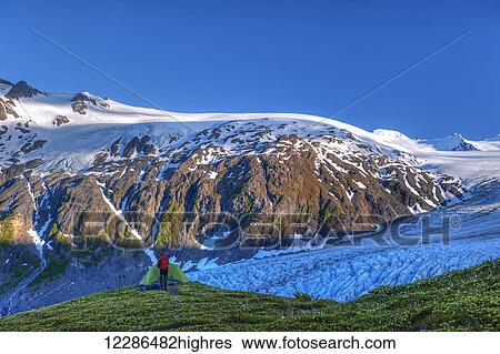 A man camping near Exit Glacier on the Harding Ice Field Trail in Kenai Fjords National Park on the Kenai Peninsula; Alaska, United States of America View Large Photo Image Stock Photograph - A man camping near Exit Glacier on the Harding Ice Field Trail in Kenai Fjords National Park on the Kenai Peninsula; Alaska, United States of America. Fotosearch