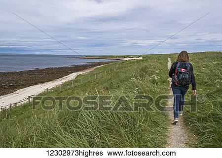 A man with a backpack walks on a trail along the coast; John O'Groats, Scotland View Large Photo Image Stock Photograph - A man with a backpack walks on a trail along the coast; John O'Groats, Scotland. Fotosearch