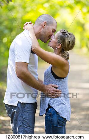 Stock Photograph - A married couple spending quality time together walking in a park; Edmonton, Alberta, Canada. Fotosearch