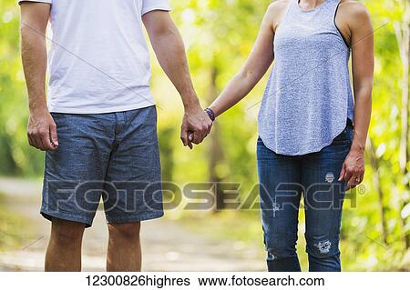 Stock Photograph - A married couple spending quality time together walking in a park; Edmonton, Alberta, Canada. Fotosearch
