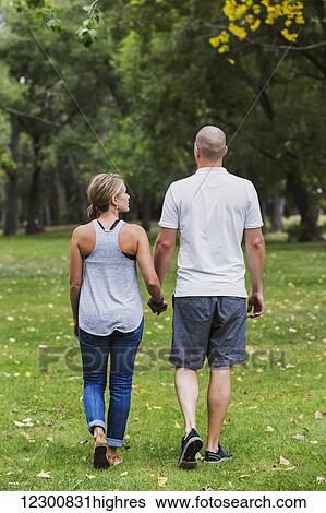 Stock Photograph - A married couple spending quality time together walking in a park; Edmonton, Alberta, Canada. Fotosearch