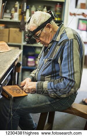 Stock Photograph - A mature man working on a leather piece; Waimea, Island of Hawaii, Hawaii, United States of America. Fotosearch