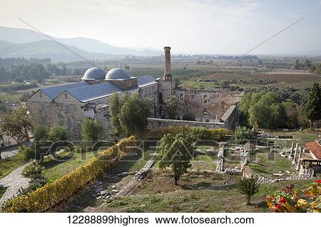 Stock Photograph - A minaret at a mosque and landscape with mountains in the distance; Ephesus, Turkey. Fotosearch