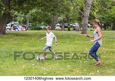 A mother playing soccer with her son in a park during a family outing; Edmonton, Alberta, Canada View Large Photo Image Stock Photograph - A mother playing soccer with her son in a park during a family outing; Edmonton, Alberta, Canada. Fotosearch