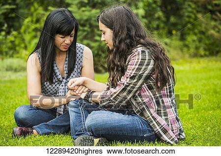 Stock Photograph - A mother praying with her daughter outdoors; Sherwood Park, Alberta, Canada. Fotosearch