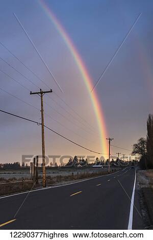 Stock Photograph - A rainbow brightens a sky; Astoria, Oregon, United States of America. Fotosearch