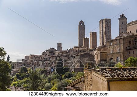 Stock Photograph - A rooftop viewpoint of the walled medieval village of San Gimignano in the Province of Siena; San Gimignano, Siena, Tuscany, Italy. Fotosearch