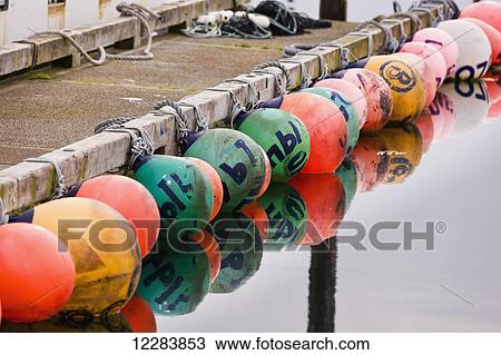 A row of multicolored buoys tied to a dock in Sand Point Harbor, Southwestern Alaska, USA, Summer View Large Photo Image Stock Image - A row of multicolored buoys tied to a dock in Sand Point Harbor, Southwestern Alaska, USA, Summer . Fotosearch