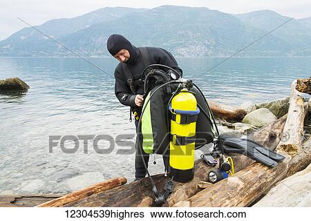 A scuba diver prepares his equipment before making a dive, Britannia Beach; Howe Sound, British Columbia, Canada View Large Photo Image Stock Photograph - A scuba diver prepares his equipment before making a dive, Britannia Beach; Howe Sound, British Columbia, Canada. Fotosearch