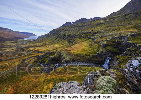 Stock Photograph - A small waterfall on the rugged landscape of Mjoifjordur, East Fjords; Iceland. Fotosearch