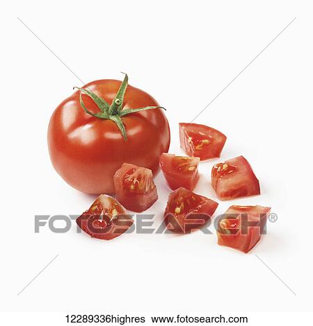 Stock Photograph - A tomato with diced pieces of tomato on a white background; Toronto, Ontario, Canada. Fotosearch
