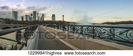 A walkway with a city skyline in the background; Niagara Falls, Ontario, Canada View Large Photo Image Stock Photograph - A walkway with a city skyline in the background; Niagara Falls, Ontario, Canada. Fotosearch
