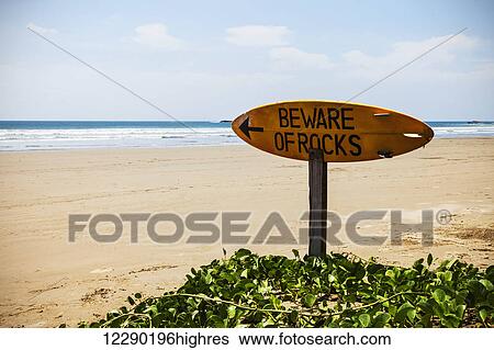 Stock Photograph - A warning sign on a surfboard in Playa Hermosa; Nicaragua. Fotosearch
